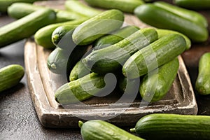 Raw Organic Mini Baby Cucumbers on wooden board. Ready to Eat