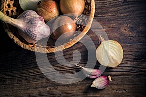 Raw organic onions and garlic on rustic wooden background. Selective focus.