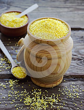 Raw organic polenta corn meal in a wooden bowl