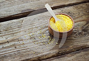 Raw organic polenta corn meal in a wooden bowl