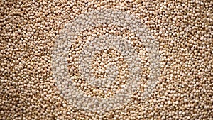 Raw organic quinoa grains on rotating background. Seeds texture. Food ingredient background. Top view, healthy lifestyle