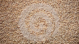 Raw organic quinoa grains on rotating background. Seeds texture. Food ingredient background. Top view, healthy lifestyle