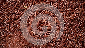 Raw organic rice berry, brown rice mixed texture on rotating background. Food ingredient concept. Top view, healthy