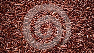 Raw organic rice berry, brown rice mixed texture on rotating background. Food ingredient concept. Top view, healthy