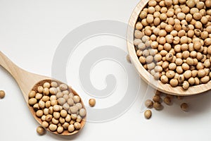 Raw organic soybeans in wooden bowl on white background.