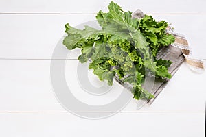 Raw Organic Turnip Greens Ready to Eat on a white wooden background with copy space