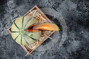 Raw Organic Tuscan Melon Cantaloupe. Yellow pieces of melon on a wooden board on a dark background, banner, menu, recipe place for