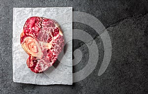 Raw osso buco veal shank on slate background. Top view