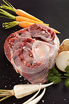 Raw ossobuco steak with fresh vegetables.