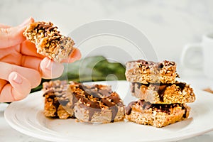 Raw Paleo energy bars made with healthy nuts and dried fruits. Homemade Snack on a white marble table. Diet detox food concept..