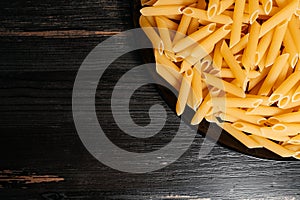 raw pasta in a black plate on a black table