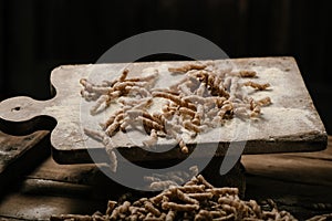 Raw pasta busiate on wooden table