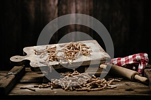 Raw pasta busiate on wooden table