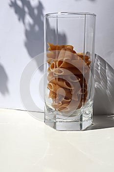 Raw pasta in a clear glass