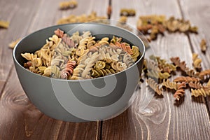 Raw pasta fusilli on brown wood