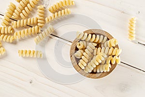 Raw pasta fusilli bucati on grey wood