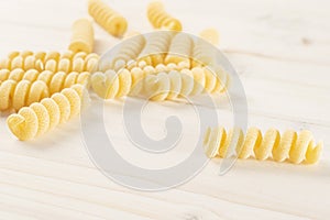 Raw pasta fusilli bucati on grey wood