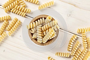 Raw pasta fusilli bucati on grey wood