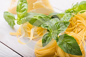 Raw pasta, green basil and chesse