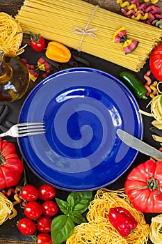 Raw pasta with ingridients and blue plate