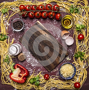 Raw pasta, lined frame around ingredients border ,place for text on wooden rustic background top view