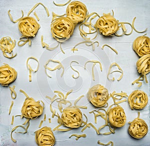 Raw pasta nest laid out with word pasta rustic wooden background top view