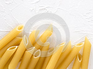 raw pasta penne on white background
