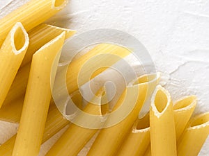 raw pasta penne on white background