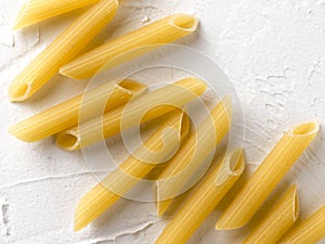 raw pasta penne on white background