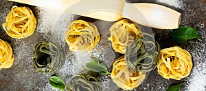 Raw pasta Tagliatelle Paglia e Fieno on a dark background. Selective focus. Space for text. Top view photo