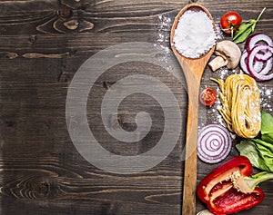 Raw pasta with tomatoes, basil,parmesan and oil, cooking Ingredients on rustic wooden background, top view, place for text