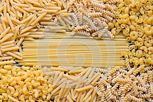 Raw pasta various kinds of uncooked pasta macaroni spaghetti and noodles on wooden, Italian food culinary concept, Collection of