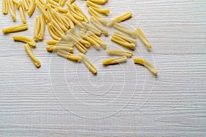 Raw pasta on white wood background