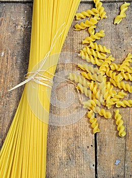 Raw pasta on wooden background