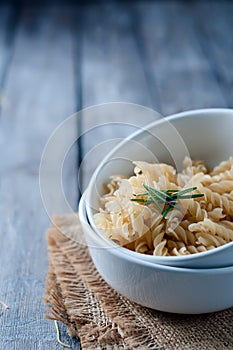 Raw pasta on wooden background