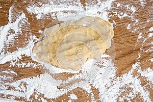 Raw Pastry Dough on Floured Wooden Kitchen Surface