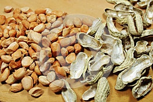Raw Peanut Kernels and Empty Peanut Shells on Wooden Table