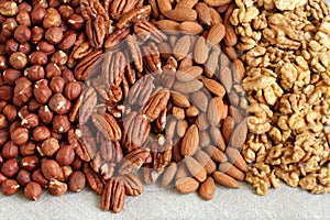 Raw peeled hazelnuts, pecans, almonds and walnuts on a linen cloth. Closeup. Macro