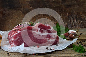 Raw piece meat of pork and spices marinade on wooden background. For steak, roasting, stewing. Space for text