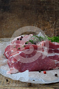 Raw piece meat of pork and spices marinade on wooden background. For steak, roasting, stewing. Space for text