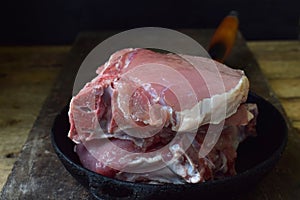 Raw piece meat of pork and spices marinade on wooden background. For steak, roasting, stewing. Space for text