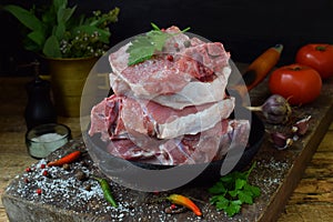 Raw piece meat of pork and spices marinade on wooden background. For steak, roasting, stewing. Space for text