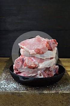 Raw piece meat of pork and spices marinade on wooden background. For steak, roasting, stewing. Space for text