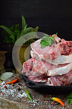 Raw piece meat of pork and spices marinade on wooden background. For steak, roasting, stewing. Space for text