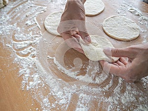 Raw pirozhki with cabbage in the cooking process.