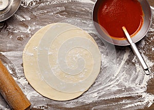 Raw Pizza Base And Ketchup. Rolled Out Dough photo