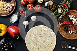 Raw pizza ingredients on black texture table background