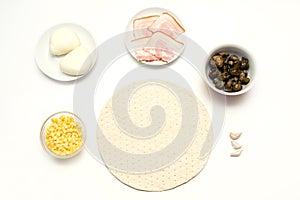 Raw pizza ingredients, mozzarella, dough, corn, salami, mushrooms on white background, cooking process, homemade food