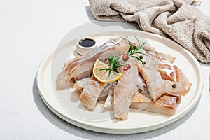 Raw pollock (Pollachius virens) fillet. Fresh fish for healthy food lifestyle. Spices and herbs