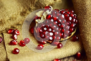 Raw pomegranate with seeds on sacking